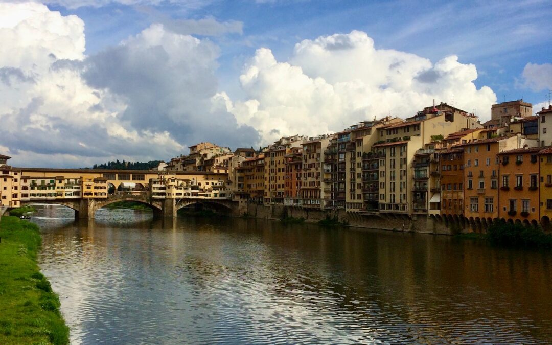 The Ponte Vecchio and riverside buildings along the Arno in Florence under a cloudy sky