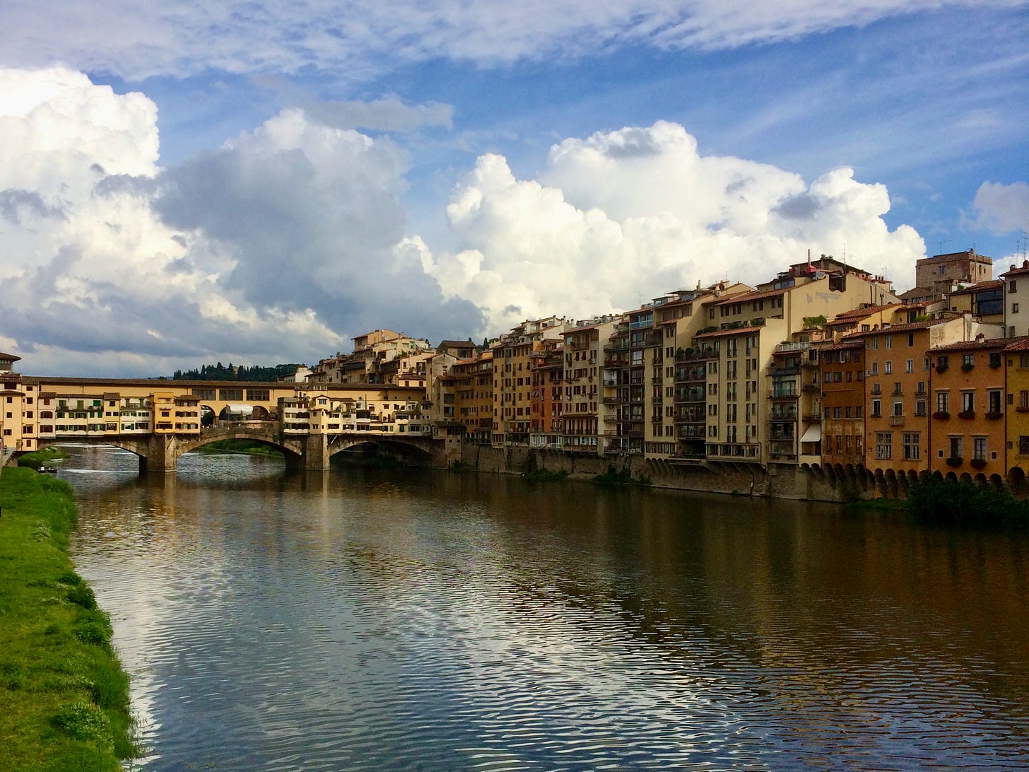 The Ponte Vecchio and riverside buildings along the Arno in Florence under a cloudy sky